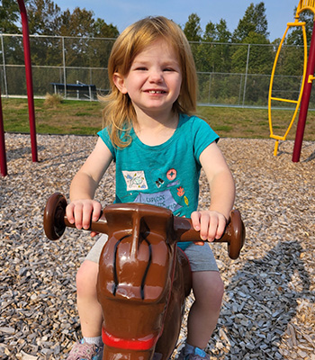 seedling playing outside on rocking horse